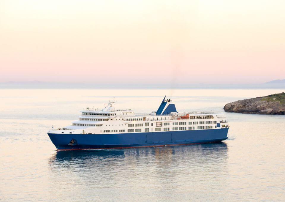doprava Řecko Západ slunce a modrá bílá trajektová loď na řeckých ostrovech